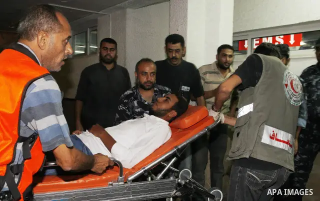 Palestinians wheel a wounded man following an Israeli attack in Gaza City on August 19, 2011. Photo by Mahmud Nassar
