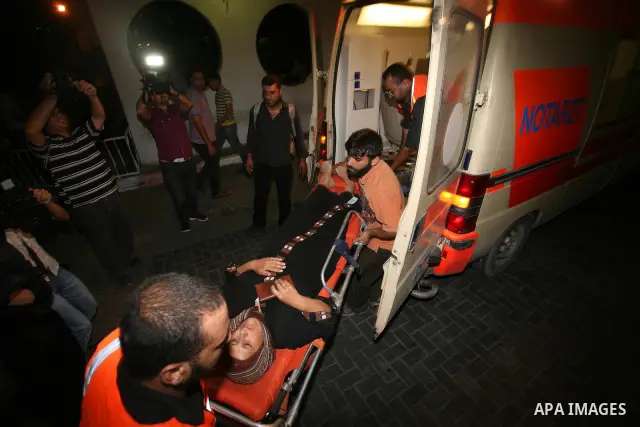 Palestinians wheel a wounded woman following an Israeli attack in Gaza City on August 19, 2011. Photo by Mahmud Nassar