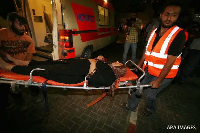 Palestinians wheel a wounded woman following an Israeli attack in Gaza City on August 19, 2011. Photo by Mahmud Nassar