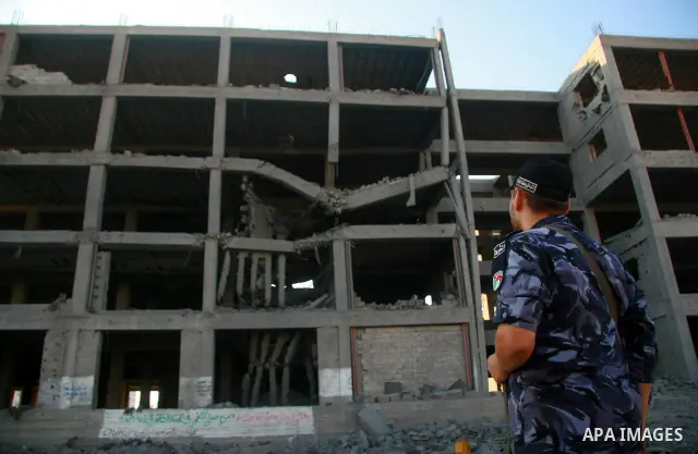 A Hamas policeman stands past a damaged government building after an Israeli air strike in Gaza August 19, 2011. Israeli aircraft struck Hamas security installations in Gaza on Friday, killing at least one Palestinian, i...