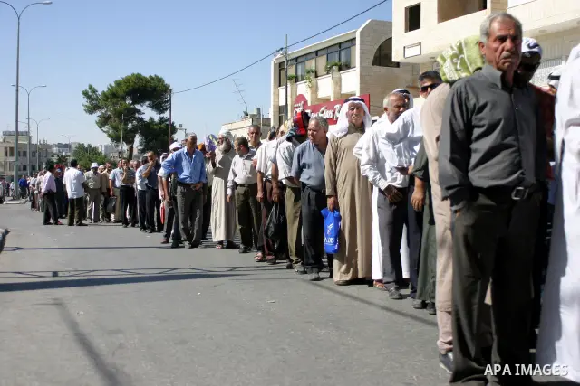Palestinian Muslims walk through an Israeli checkpoint on the outskirts of the West Bank city of Bethlehem on August 19, 2011 as they wait to cross into Jerusalem on their way to pray at the Al Aqsa Mosque on the third F...