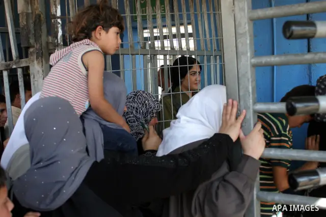 Palestinian Muslims wait at an Israeli checkpoint on the outskirts of the West Bank city of Bethlehem on August 19, 2011 as they wait to cross into Jerusalem to attend on their way to pray at the Al Aqsa Mosque on the th...