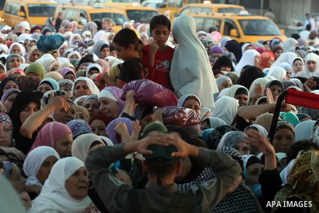 Palestinian women wait to cross the Qalandia checkpoint on their way to pray at the Al Aqsa Mosque on the third Friday of the Muslim holy month of Ramadan, at the Qalandia checkpoint between the West Bank city of Ramalla...