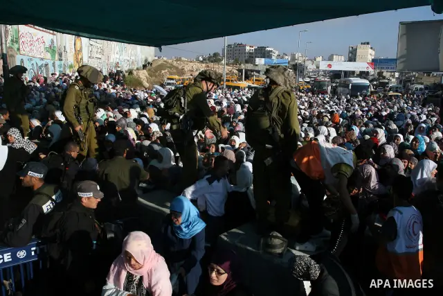 Palestinian women wait to cross the Qalandia checkpoint on their way to pray at the Al Aqsa Mosque on the third Friday of the Muslim holy month of Ramadan, at the Qalandia checkpoint between the West Bank city of Ramalla...