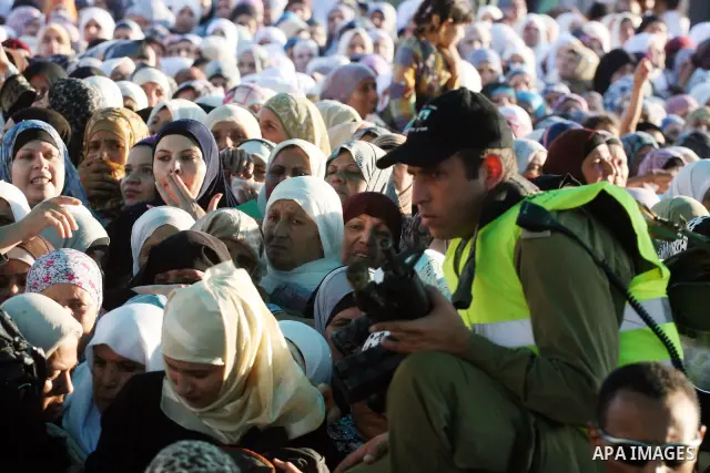 Palestinian women wait to cross the Qalandia checkpoint on their way to pray at the Al Aqsa Mosque on the third Friday of the Muslim holy month of Ramadan, at the Qalandia checkpoint between the West Bank city of Ramalla...