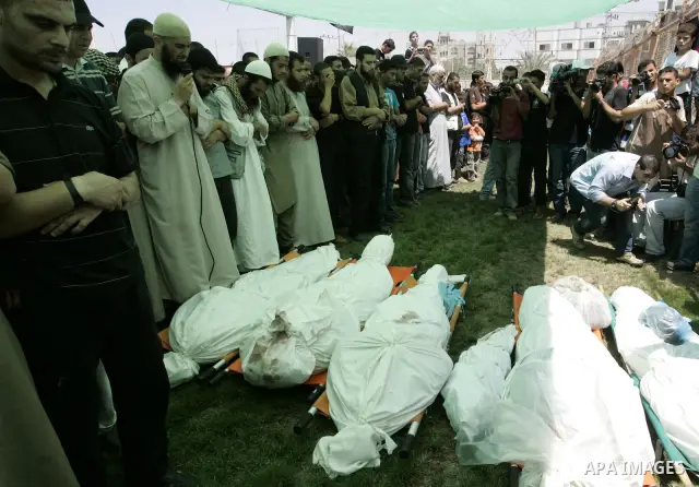 Palestinians pray near the bodies of people killed in Israeli air strikes during a funeral in the Rafah refugee camp, southern Gaza Strip, on August 19, 2011. Israeli fighter jets bombed Gaza, killing a teenager and inju...