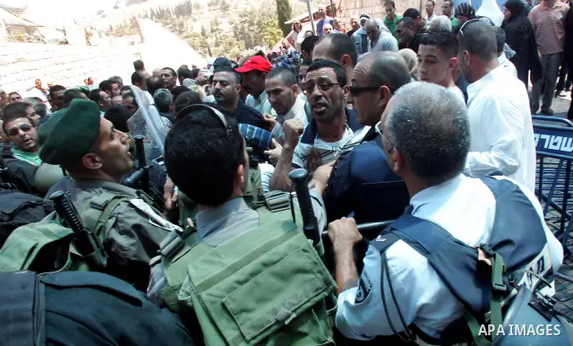 Israeli police and riot police keep back a crowd of Palestinian Muslims who push to break past barricades at the Damascus gate (not seen) as a police water cannon sprays the crowds with a 'skunk' liquid on 19 August 2011...
