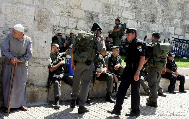Israeli border policemen keep watch as Palestinian Muslim worshipers perform the third Friday prayer of Islam's holy month of Ramadan outside Damascus Gate in Jerusalem's Old City on August 19, 2011. Photo by Mahfouz Abu...