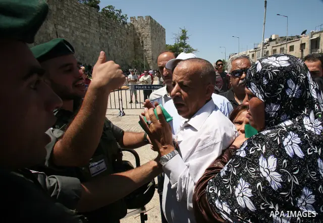 Palestinian Muslims gesture as they try to get past Israeli police at a barricade at the Damascus Gate (not seen) in East Jerusalem as Israel restricts attendance at the al-Aqsa Mosque in Jerusalem's Old City for the thi...