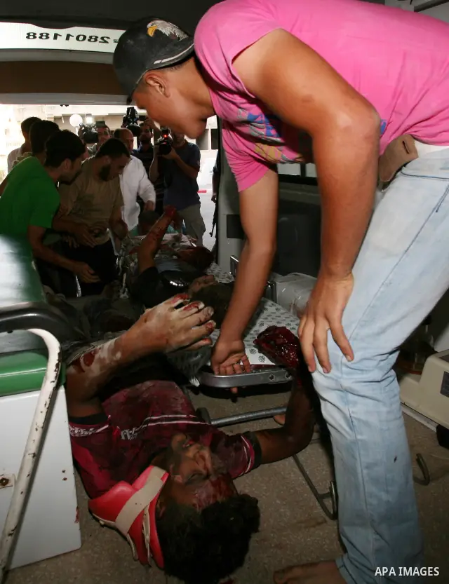 Palestinians carry a wounded boy into Al-Shifa hospital following Israeli air attacks, in Gaza City, Gaza Strip, 19 August 2011. Photo by Mahmud Nassar