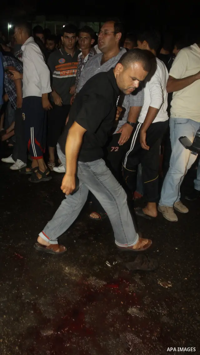Palestinians inspect the Blood following an Israeli airstrike killing three Palestinian who were riding it, at the main road in Gaza City, Friday, Aug. 19, 2011. Palestinian official said that Dr. Monzer Qrakea, 35, and...