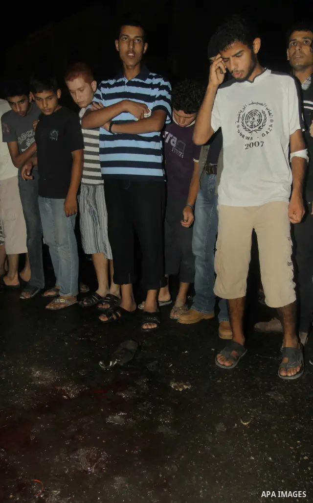 Palestinians inspect the Blood following an Israeli airstrike killing three Palestinian who were riding it, at the main road in Gaza City, Friday, Aug. 19, 2011. Palestinian official said that Dr. Monzer Qrakea, 35, and...