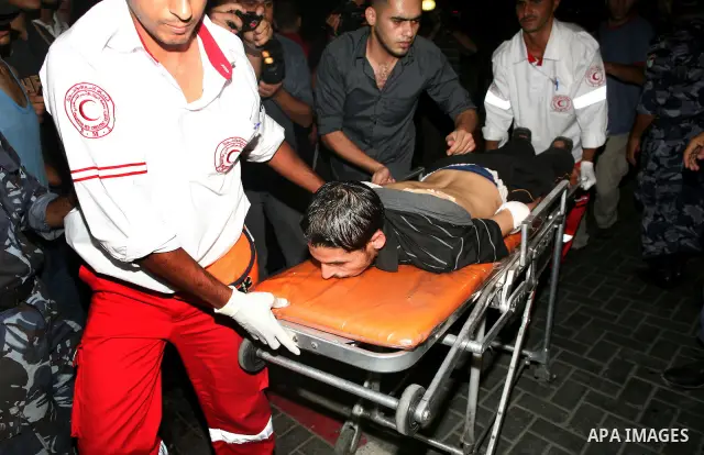 A Palestinian man lies injured on a stretcher after being wounded in an Israeli air strike, at a hospital in Gaza City on August 19, 2011. Three Palestinians were killed -- one of them a five-year-old boy -- and three mo...