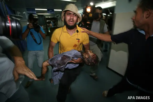 A Palestinian man carries the body of Islam Greagea, a five-year-old boy killed in an Israeli air strike, at a hospital in Gaza City on August 19, 2011. Three Palestinians were killed -- one of them a five-year-old boy -...