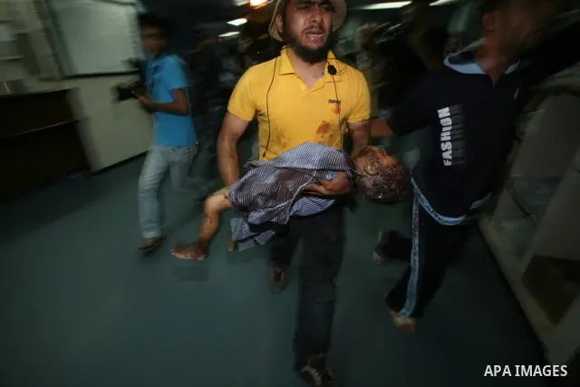 A Palestinian man carries the body of Islam Greagea, a five-year-old boy killed in an Israeli air strike, at a hospital in Gaza City on August 19, 2011. Three Palestinians were killed -- one of them a five-year-old boy -...