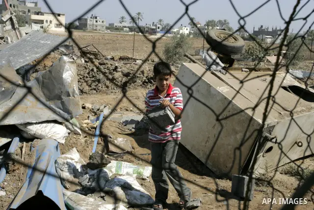 A Palestinian boy walks at the site of an overnight Israeli air raid in Khan Yunis in the southern Gaza Strip on August 20, 2011 on a third day of escalating Israeli-Palestinian tensions. Photo by Abed Rahim Khatib