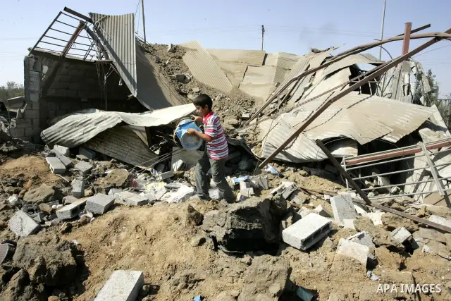 A Palestinian boy walks at the site of an overnight Israeli air raid in Khan Yunis in the southern Gaza Strip on August 20, 2011 on a third day of escalating Israeli-Palestinian tensions. Photo by Abed Rahim Khatib