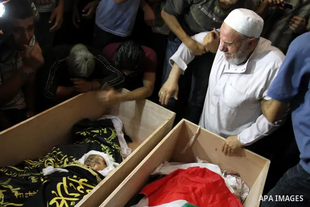 Palestinians mourn over the bodies of Moataz Qreqa, a commander of Islamic Jihad's Al-Quds Brigade, his five-year-old son Islam and his brother Munzer during their funeral in Gaza City on August 20, 2011 after all three...