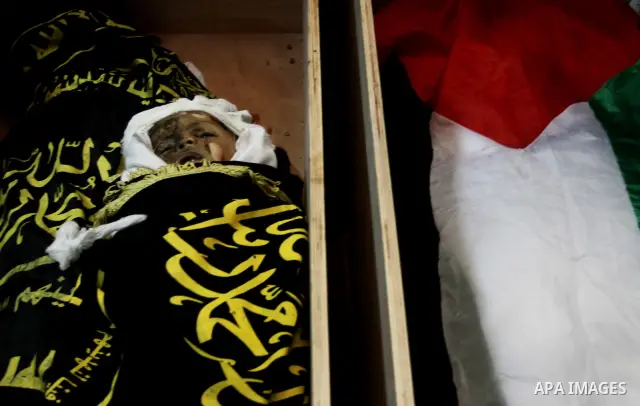 The bodies of Moataz Qreqa, a commander of Islamic Jihad's Al-Quds Brigade, his five-year-old son Islam and his brother Munzer lie in coffins during their funeral in Gaza City on August 20, 2011 after all three were kill...