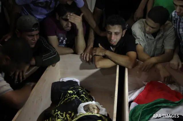 Palestinians mourn over the bodies of Moataz Qreqa, a commander of Islamic Jihad's Al-Quds Brigade, his five-year-old son Islam and his brother Munzer during their funeral in Gaza City on August 20, 2011 after all three...