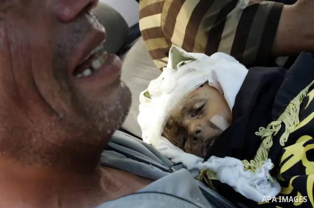 A Palestinian man carries the body of two-year-old boy Islam Qreqa during a funeral in Gaza City on August 20, 2011. Palestinians said at least nine militants have died in multiple Israeli strikes, as well as two childre...