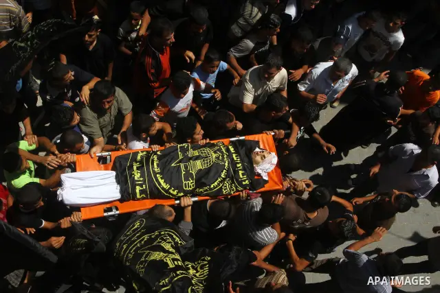 Palestinian mourners carry the body of Anwar Isleem, a commander in the Islamic Jihad militant during his funeral in Bureij Refugee Camp in central Gaza Strip on August 20, 2011 Anwar Isleem and Emad Abu Aabdeh were kill...