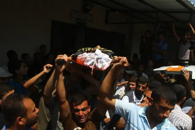 Palestinian mourners carry the body of Anwar Isleem, a commander in the Islamic Jihad militant during his funeral in Bureij Refugee Camp in central Gaza Strip on August 20, 2011 Anwar Isleem and Emad Abu Aabdeh were kill...