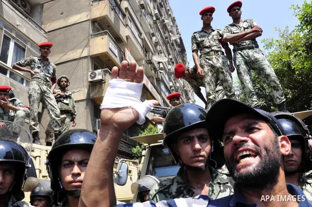 Egyptian military policemen stand guard as demonstrators wave Egyptian and Palestinian (L) flags during a protest outside the Israeli embassy in Cairo on August 20, 2011. Egypt decided to recall its ambassador from Israe...