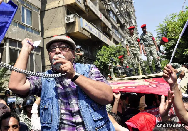 Egyptian military policemen stand guard as demonstrators wave Egyptian and Palestinian (L) flags during a protest outside the Israeli embassy in Cairo on August 20, 2011. Egypt decided to recall its ambassador from Israe...