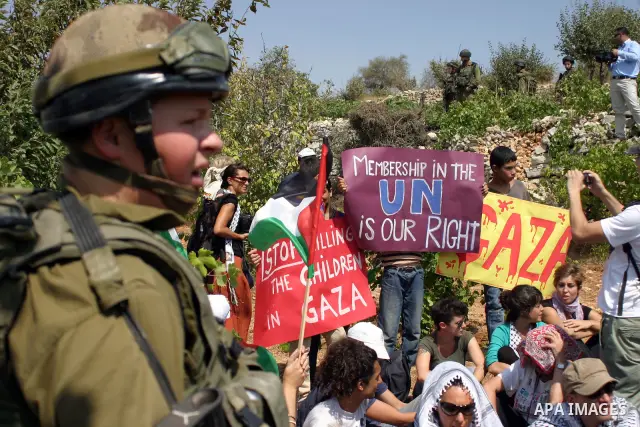 Israeli soldiers stand guard as Palestinians demonstrate along with left-wing Israelis and foreign peace activists in Beit Omar, near the West Bank city of Hebron on August 20, 2011 for the creation of a Palesitnian stat...