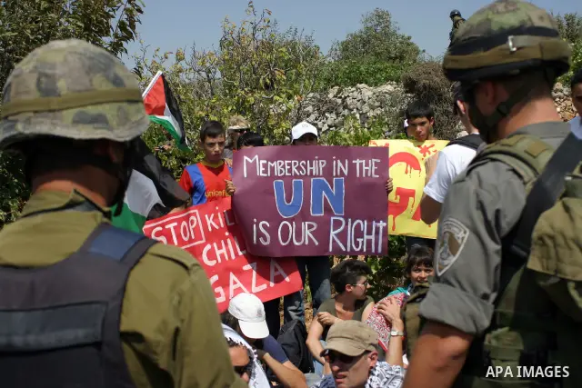 Israeli soldiers stand guard as Palestinians demonstrate along with left-wing Israelis and foreign peace activists in Beit Omar, near the West Bank city of Hebron on August 20, 2011 for the creation of a Palesitnian stat...