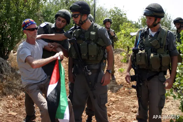 A demonstrator scuffle with Israeli soldiers during a demonstration by locals, left-wing Israelis, foreigner peace activists in Beit Omar, near the West Bank city of Hebron on August 20, 2011 against the latest Israeli a...
