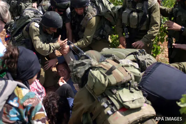 A demonstrator shouts anti-occupation slogans as Israeli soldiers try to detain him during a demonstration by locals, left-wing Israelis, foreigner peace activists in Beit Omar, near the West Bank city of Hebron on Augus...