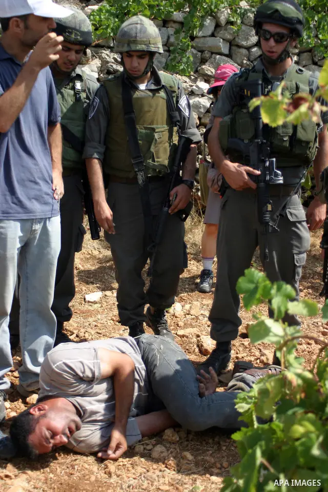 A demonstrator shouts anti-occupation slogans as Israeli soldiers try to detain him during a demonstration by locals, left-wing Israelis, foreigner peace activists in Beit Omar, near the West Bank city of Hebron on Augus...