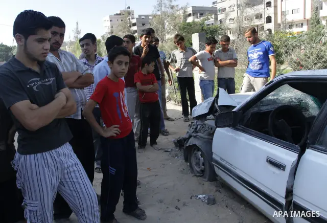 Palestinians inspect the damage at a Hamas training camp following an Israeli airstrike in Gaza City, Sunday, on Aug. 21, 2011. Militants in the Hamas-ruled Gaza Strip bombarded southern Israel with rockets and mortars S...