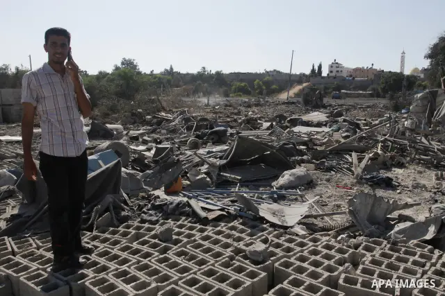 Palestinians inspect the damage at a Hamas training camp following an Israeli airstrike in Gaza City, Sunday, on Aug. 21, 2011. Militants in the Hamas-ruled Gaza Strip bombarded southern Israel with rockets and mortars S...