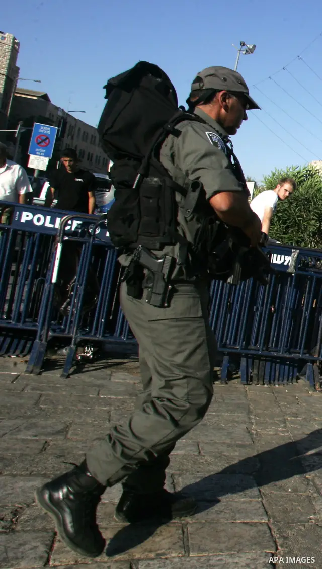 Palestinian Muslims walk past Israeli soldiers at a barricade near the Damascus Gate in East Jerusalem as Israel restricts attendance at the al-Aqsa Mosque in Jerusalem's Old City on August 21,2011.. Photo by Mahfouz Abu...