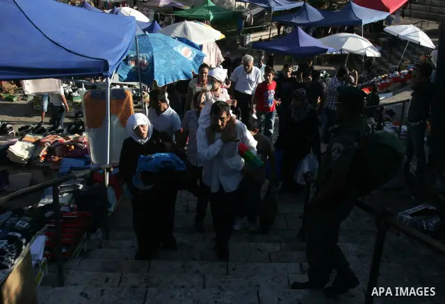 Palestinian Muslims walk past Israeli soldiers at a barricade near the Damascus Gate in East Jerusalem as Israel restricts attendance at the al-Aqsa Mosque in Jerusalem's Old City on August 21,2011.. Photo by Mahfouz Abu...