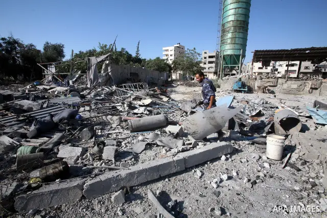 A Hamas security man inspects the damage at a Hamas training camp following an Israeli air-strike in Gaza City, Sunday, Aug. 21, 2011. Militants in the Hamas-ruled Gaza Strip bombarded southern Israel with rockets and mo...