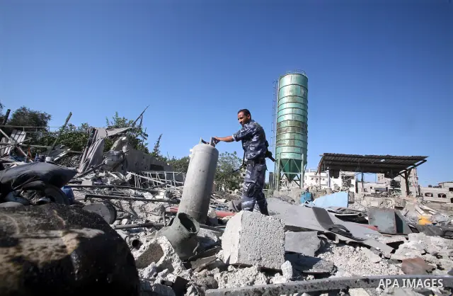 A Hamas security man inspects the damage at a Hamas training camp following an Israeli air-strike in Gaza City, Sunday, Aug. 21, 2011. Militants in the Hamas-ruled Gaza Strip bombarded southern Israel with rockets and mo...