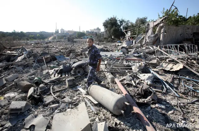 A Hamas security man inspects the damage at a Hamas training camp following an Israeli air-strike in Gaza City, Sunday, Aug. 21, 2011. Militants in the Hamas-ruled Gaza Strip bombarded southern Israel with rockets and mo...