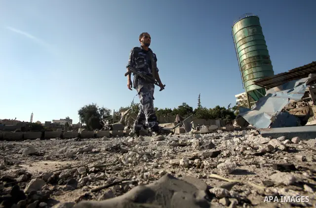 A Hamas security man inspects the damage at a Hamas training camp following an Israeli air-strike in Gaza City, Sunday, Aug. 21, 2011. Militants in the Hamas-ruled Gaza Strip bombarded southern Israel with rockets and mo...