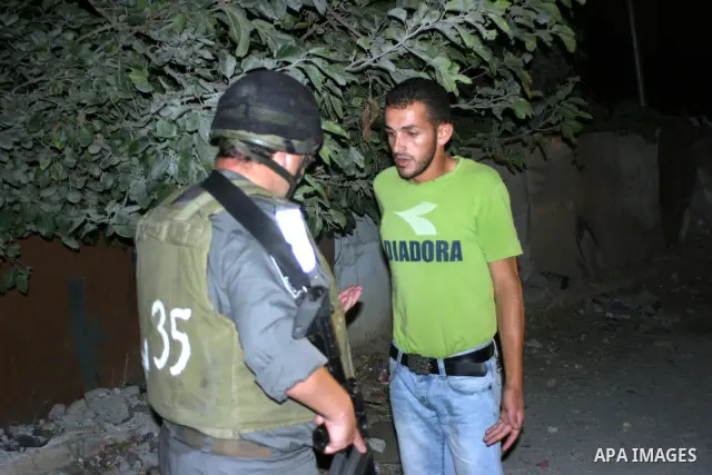 Israeli soldiers surround a neighbourhood during a military operation in the West Bank city of Hebron, early on 22 August 2011. Israel declared all-out war on Hamas, launching air strikes on its Gaza Strip stronghold and...