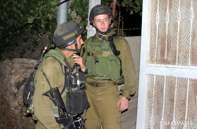 Israeli soldiers surround a neighbourhood during a military operation in the West Bank city of Hebron, early on 22 August 2011. Israel declared all-out war on Hamas, launching air strikes on its Gaza Strip stronghold and...
