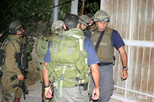 Israeli soldiers surround a neighbourhood during a military operation in the West Bank city of Hebron, early on 22 August 2011. Israel declared all-out war on Hamas, launching air strikes on its Gaza Strip stronghold and...