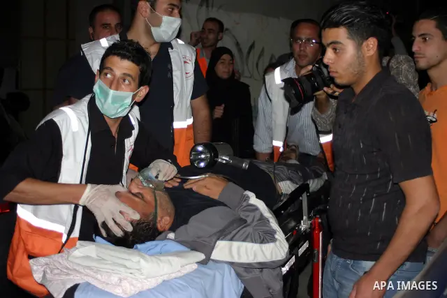 Palestinians wounded during the Israeli soldiers surround a neighbourhood during a military operation in the West Bank city of Hebron, early on 22 August 2011. Israel declared all-out war on Hamas, launching air strikes...