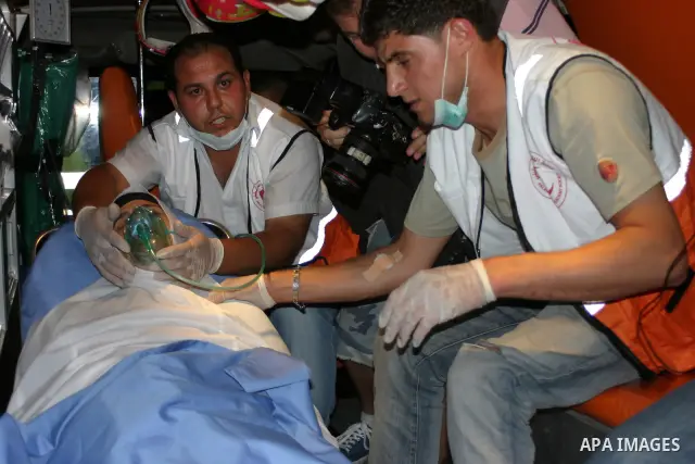 Palestinians wounded during the Israeli soldiers surround a neighbourhood during a military operation in the West Bank city of Hebron, early on 22 August 2011. Israel declared all-out war on Hamas, launching air strikes...