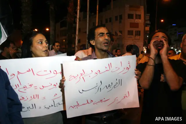 Palestinians take part in a protest against Israeli attacks over Gaza Strip in the West Bank city of Ramallah on Aug. 21, 2011. Photo by Issam Rimawi