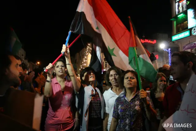 Palestinians take part in a protest against Israeli attacks over Gaza Strip in the West Bank city of Ramallah on Aug. 21, 2011. Photo by Issam Rimawi