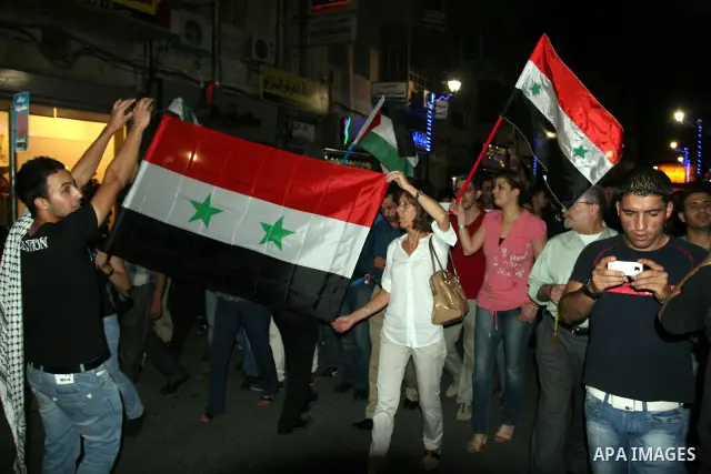 Palestinians take part in a protest against Israeli attacks over Gaza Strip in the West Bank city of Ramallah on Aug. 21, 2011. Photo by Issam Rimawi